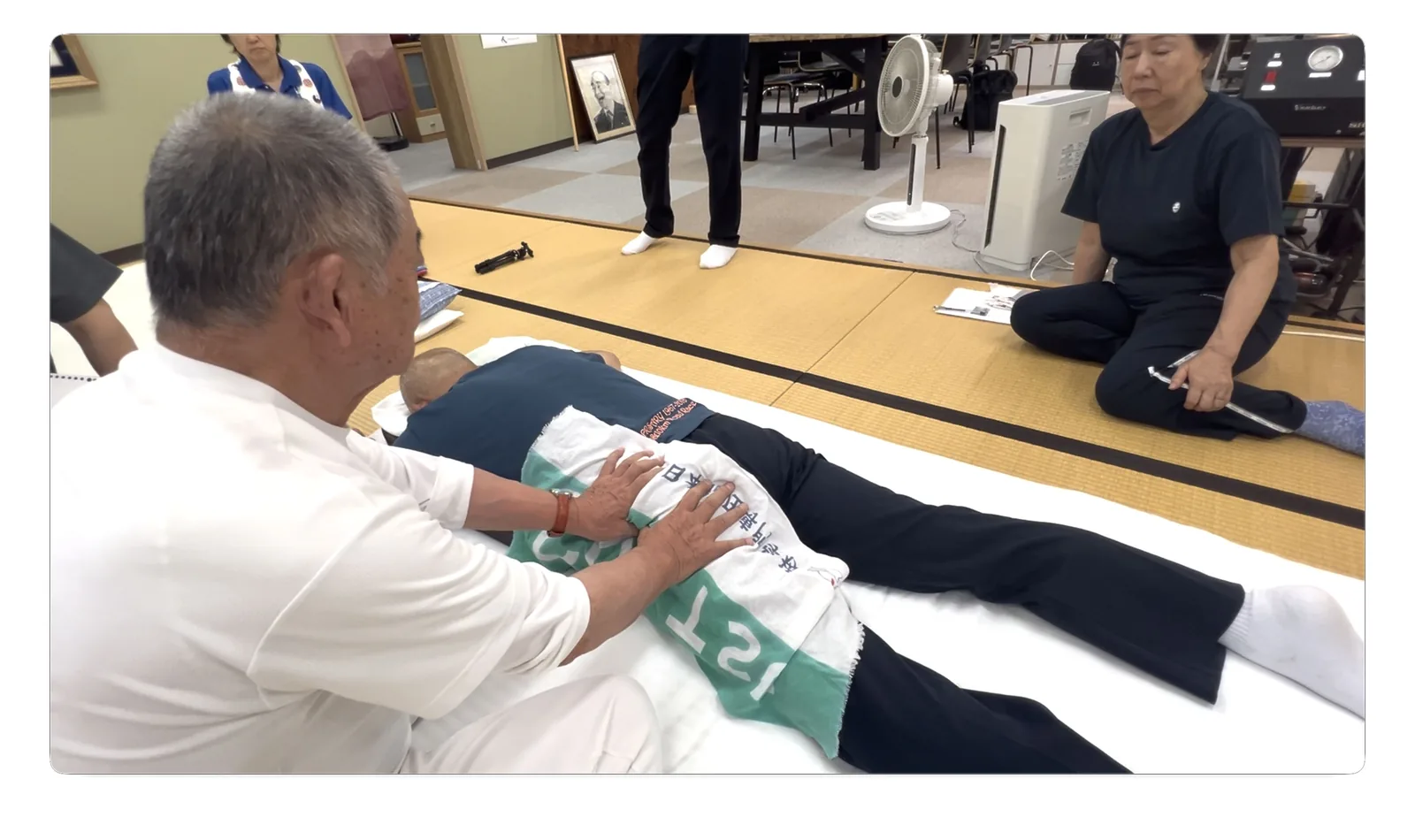 指尖で殿部を深く指圧する手技